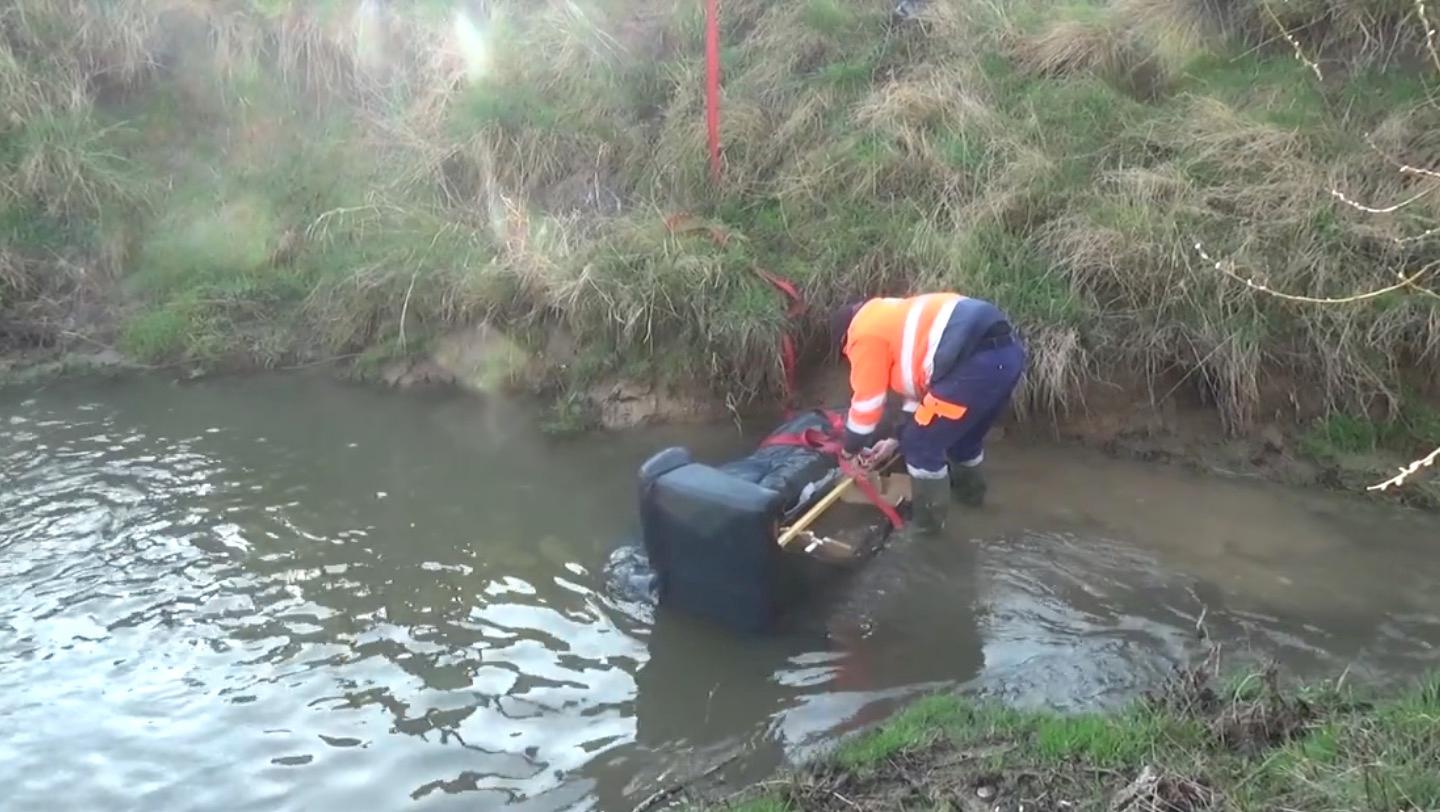 Un divan dans un fossé… situé à quelques mètres d’un parc à conteneur